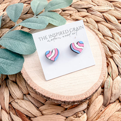 Heart-shaped earrings on a 'The Inspired Grain' branded card with leaves and wood slice in the background